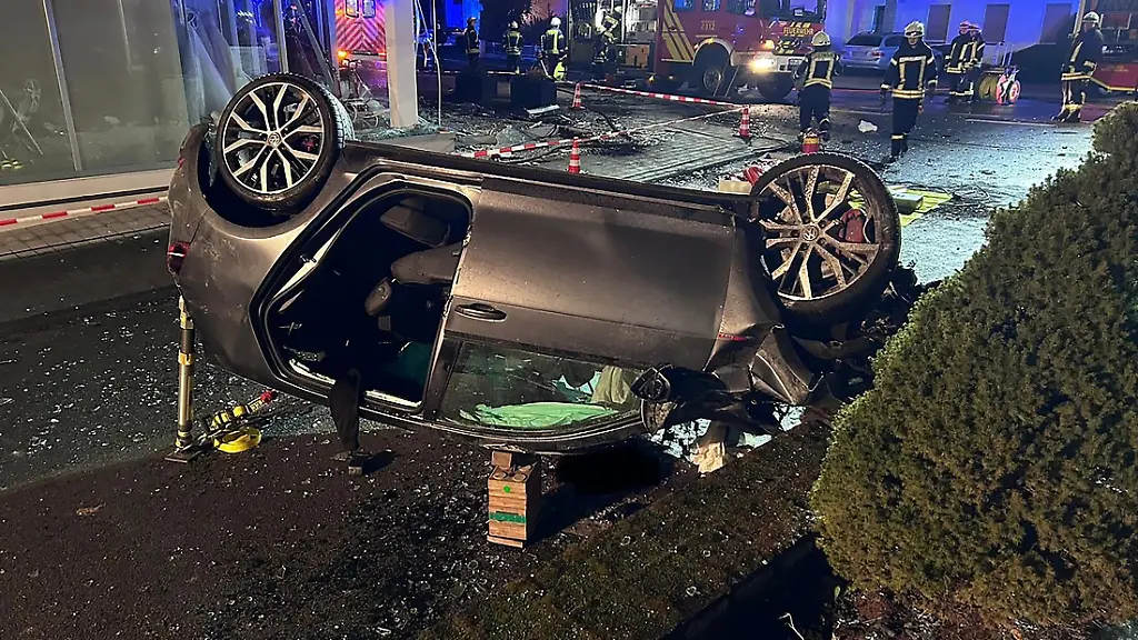 Ein-Auto-liegt-auf-dem-Dach-Der-Wagen-kam-von-der-Fahrbahn-ab-und-fuhr-durch-das-Schaufenster-eines-Modegeschaeftes