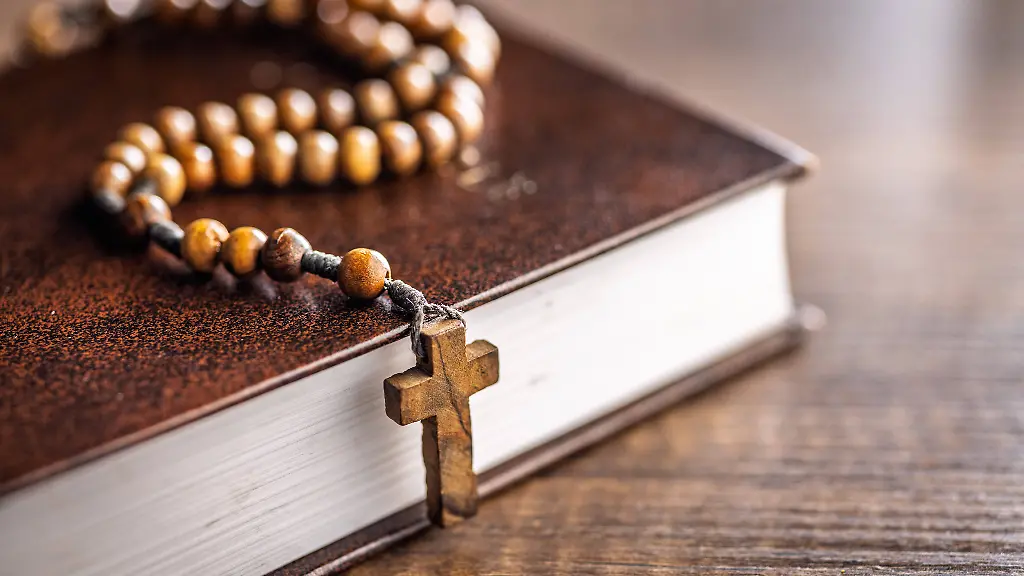 Hoelzerne-Rosenkranzperlen-und-Heilige-Bibel-auf-Holztisch-Wooden-rosary-beads-and-Holy-Bible-on-a-wooden-table-LicenseRF-Copyright-xZoonar