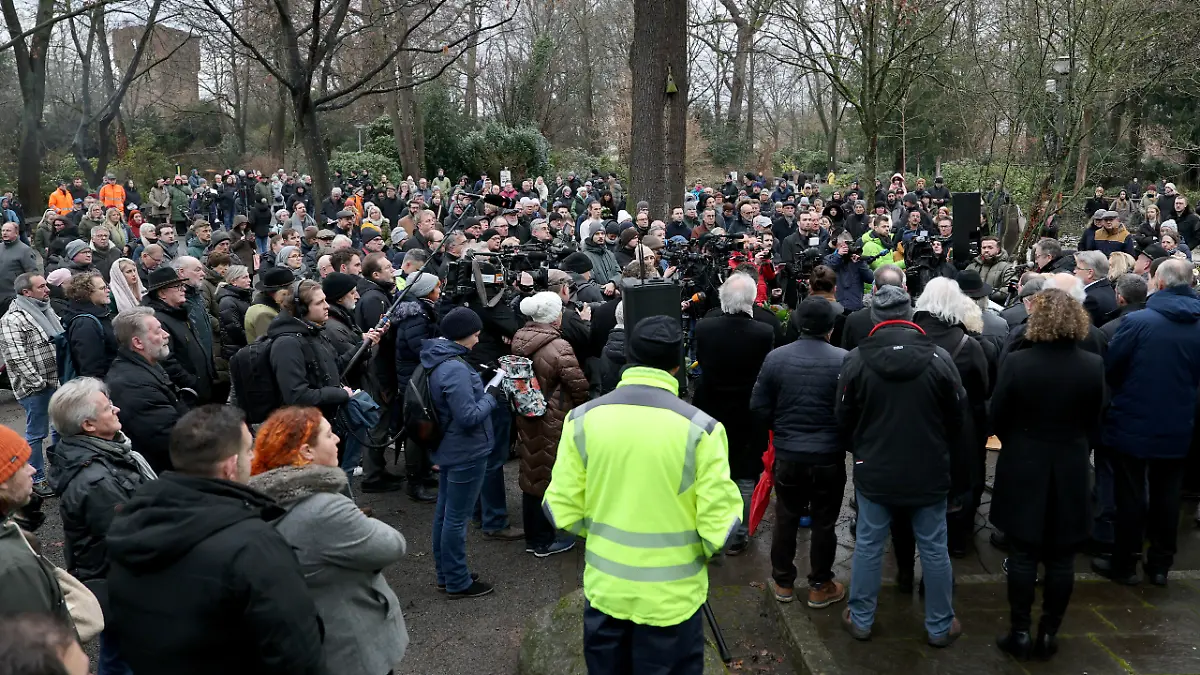 Trauernde-und-Journalisten-haben-sich-vor-einer-Kranzniederlegung-nach-dem-toedlichen-Angriff-in-einem-Park-versammelt-In-einem-Park-in-Aschaffenburg-waren-am-Vortag-ein-zweijaehriger-Junge-und-ein-41-jaehriger-Mann-getoetet-sowie-weitere-Menschen-schwer-verletzt-worden