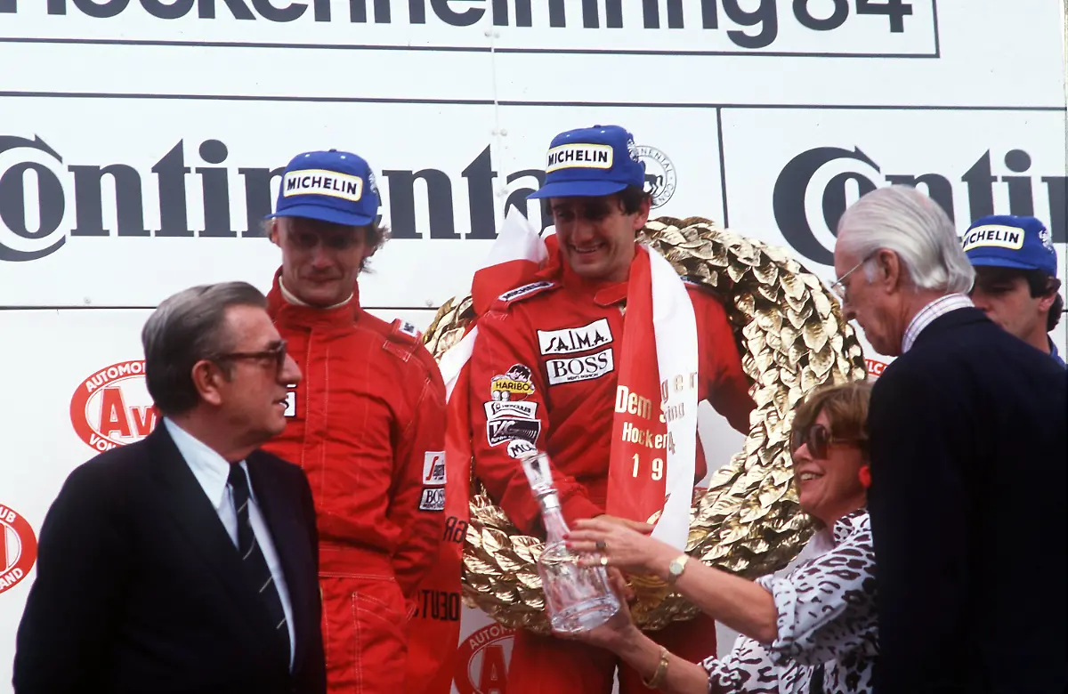 Der-zweitplatzierte-oesterreichische-Formel-1-Rennfahrer-Niki-Lauda-2-vl-mit-dem-Sieger-des-Grossen-Preises-von-Hockenheim-1984-seinem-franzoesischen-Teamkollegen-Alain-Prost-M-Ganz-rechts-der-Brite-Derek-Warwik-der-Dritter-wurde