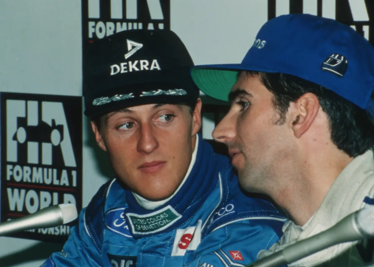 Damon-Hill-of-Britain-right-whispers-to-Michael-Schumacher-of-Germany-during-a-joint-press-conference-by-the-top-three-qualified-drivers-for-the-Japanese-Grand-Prix-at-the-Suzuka-Circuit-on-Nov-4-1994-Schumacher-kept-pole-position-while-Hill-took-second-position-on-the-grid