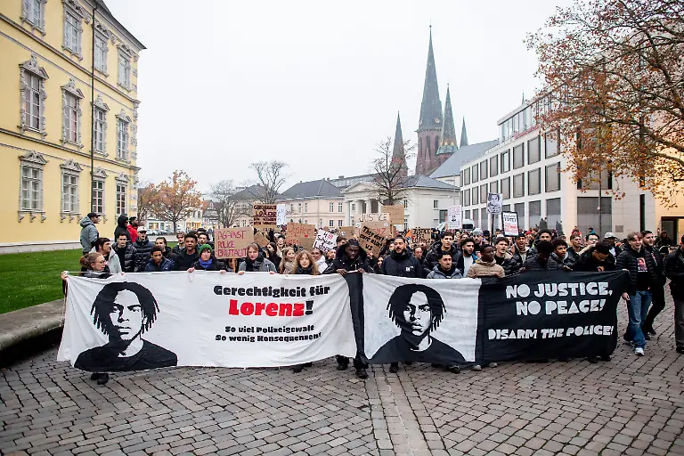 08-11-2025-Niedersachsen-Oldenburg-Zahlreiche-Menschen-nehmen-an-einer-Demonstration-der-Initiative-Gerechtigkeit-fuer-Lorenz-auf-dem-Schlossplatz-teil-Die-Initiative-fordert-eine-lueckenlose-Aufklaerung-des-Falls-und-setzt-sich-gegen-Polizeigewalt-und-Rassismus-ein-Nach-den-toedlichen-Schuessen-auf-den-21-jaehrigen-hat-die-Staatsanwaltschaft-Anklage-gegen-einen-Polizisten-wegen-fahrlaessiger-Toetung-erhoben