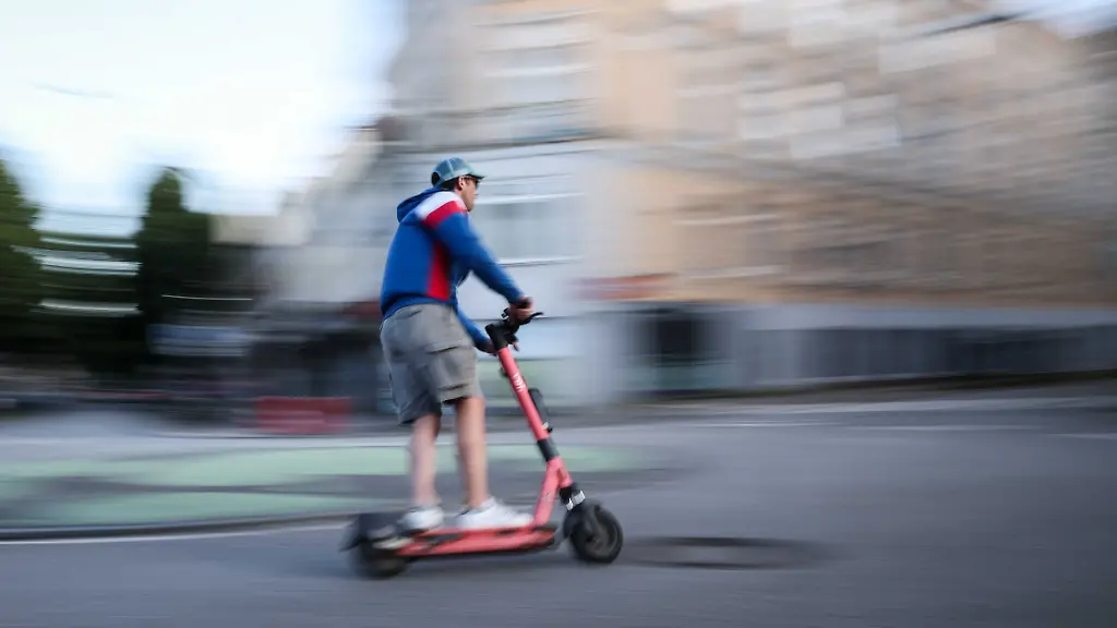 Ein-Mann-ist-auf-einem-E-Scooter-in-Hamburg-unterwegs-Aufnahme-mit-langer-Verschlusszeit-Die-Bundesregierung-plant-neue-Regeln-zu-E-Scootern