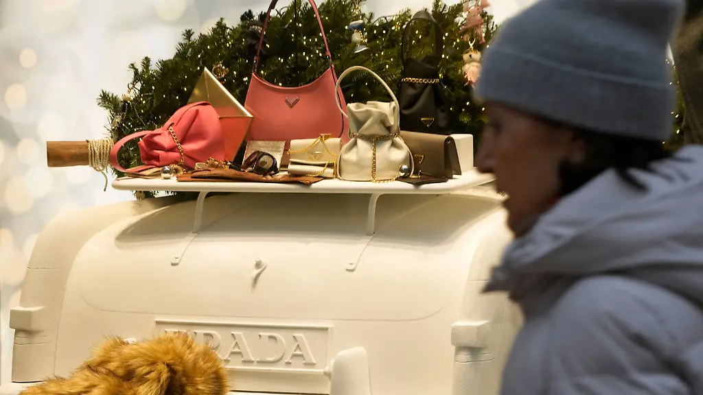 A-woman-walks-next-to-a-Prada-shop-window-in-Milan-Italy-Tuesday-Dec-2-2025