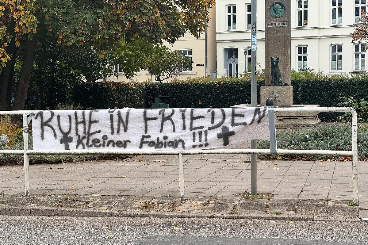 Ein-Banner-mit-der-Aufschrift-Ruhe-in-Frieden-Kleiner-Fabian-haengt-am-Rande-der-Innenstadt-Am-Vortag-wurde-in-einem-Waldstueck-bei-Klein-Upahl-ein-totes-Kind-gefunden-Eine-rechtsmedizinische-Untersuchung-soll-Klarheit-schaffen-ob-es-sich-um-den-seit-Freitag-vermissten-Fabian-handelt-Schon-unmittelbar-nach-der-grausamen-Entdeckung-hatten-die-Behoerden-kaum-noch-Zweifel-an-der-Identitaet-des-Toten-Es-muesse-davon-ausgegangen-werden-dass-es-der-Achtjaehrige-ist-teilten-Polizei-und-Staatsanwaltschaft-mit