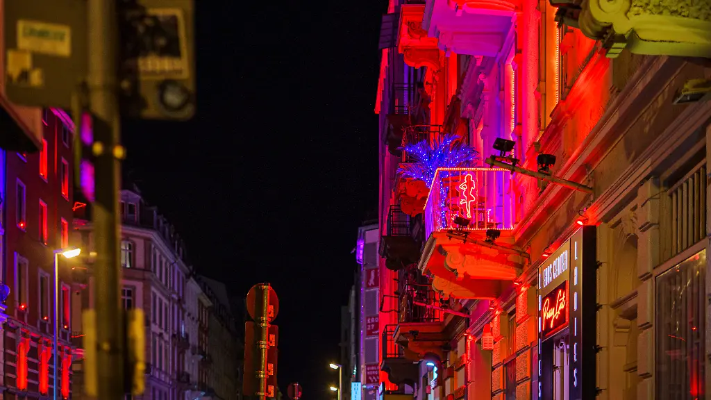 Die-rot-beleuchtete-Hausfassade-weisst-auf-koerpernahe-Dienstleistungen-hin-Das-Bahnhofsviertel-gilt-auch-als-Problemviertel-Es-hat-diesen-Ruf-aufgrund-von-Drogenhandel-offener-Drogenszene-Prostitution-illegalem-Gluecksspiel-und-Kriminalitaet-wie-Raubueberfaellen-und-Beschaffungskriminalitaet