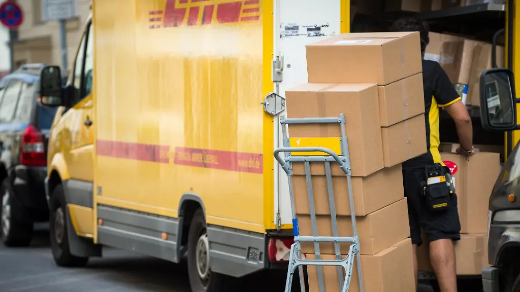 Ein-Paketbote-belaed-sein-Fahrzeug-mit-Pakten-in-Berlin-10-08-2016