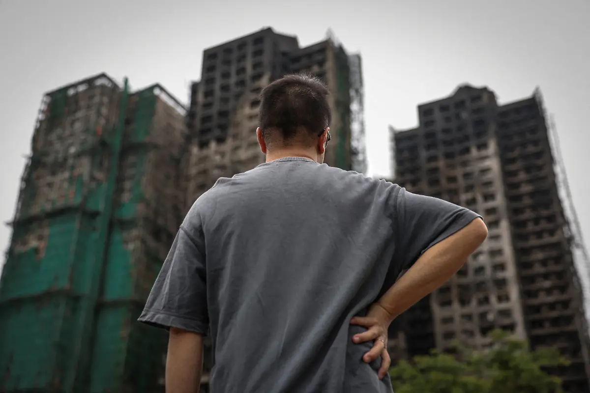 J-Wong-son-of-Wong-a-71-year-old-man-whose-image-was-captured-during-the-deadly-Wang-Fuk-Court-fire-in-a-widely-published-Reuters-photograph-poses-for-a-photo-near-the-housing-complex-during-an-interview-in-Tai-Po-Hong-Kong-China-November-30-2025-REUTERS-Tyrone-Siu-SEARCH-HONG-KONG-FIRE-PICTURE-FOR-THIS-STORY-SEARCH-WIDER-IMAGE-FOR-ALL-STORIES