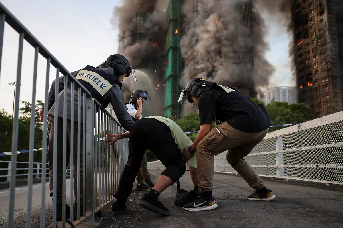 Police-assist-Wong-a-71-year-old-man-who-claims-his-wife-is-trapped-inside-Wang-Fuk-Court-housing-complex-during-a-major-fire-in-Tai-Po-Hong-Kong-China-November-26-2025-REUTERS-Tyrone-Siu-SEARCH-HONG-KONG-FIRE-PICTURE-FOR-THIS-STORY-SEARCH-WIDER-IMAGE-FOR-ALL-STORIES