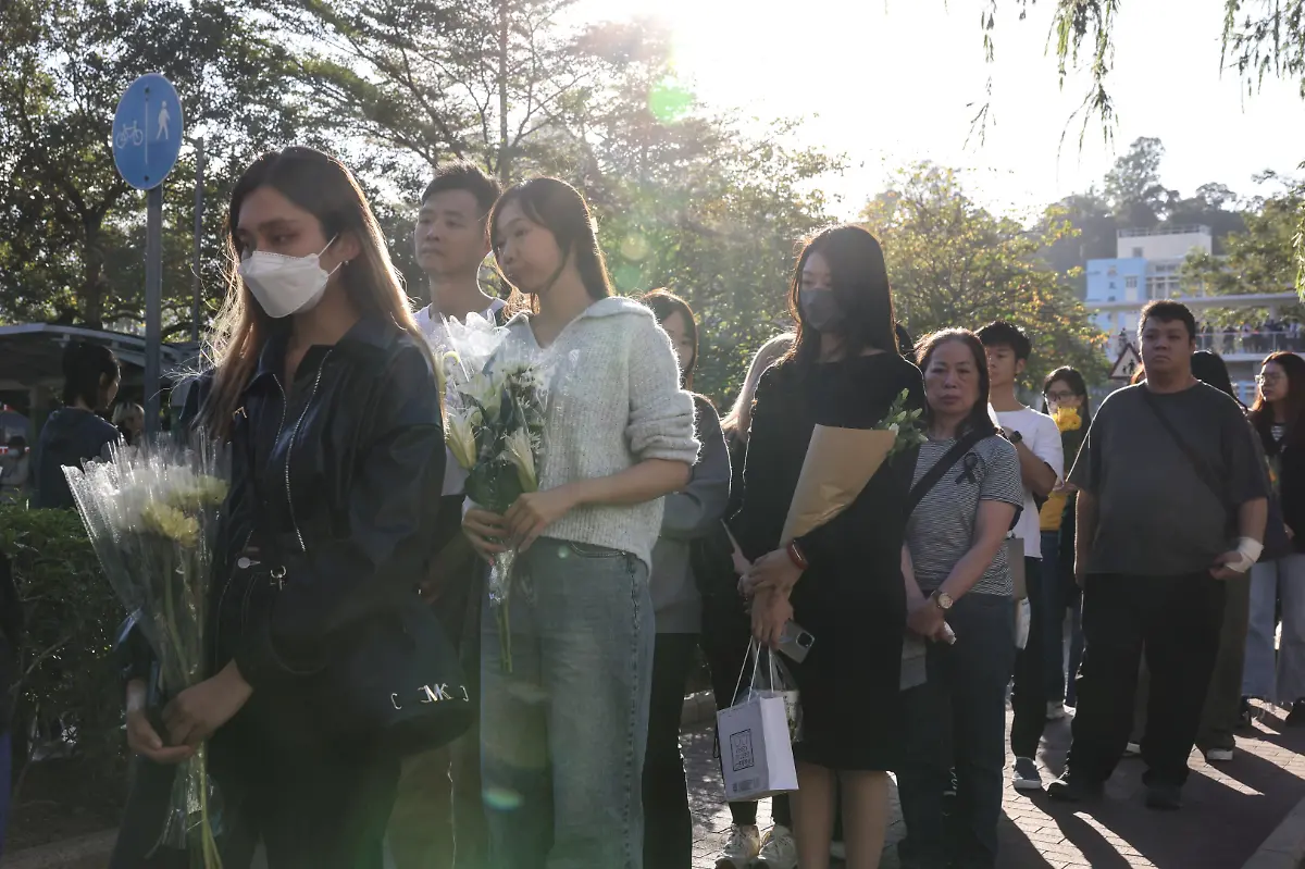 People-queue-to-place-flowers-at-a-makeshift-memorial-near-Wang-Fuk-Court-housing-complex-to-pay-tribute-to-victims-of-the-deadly-fire-at-the-housing-complex-in-Tai-Po-Hong-Kong-China-November-29-2025-REUTERS-Tyrone-Siu-SEARCH-HONG-KONG-FIRE-PICTURE-FOR-THIS-STORY-SEARCH-WIDER-IMAGE-FOR-ALL-STORIES