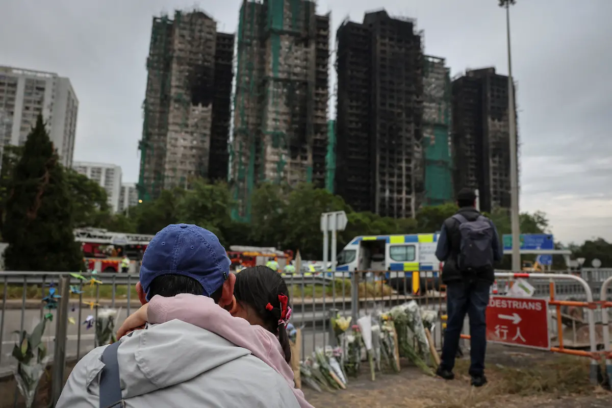 People-pay-tribute-in-front-of-the-Wang-Fuk-Court-housing-complex-following-a-deadly-fire-in-Tai-Po-Hong-Kong-China-November-30-2025-REUTERS-Tyrone-Siu-SEARCH-HONG-KONG-FIRE-PICTURE-FOR-THIS-STORY-SEARCH-WIDER-IMAGE-FOR-ALL-STORIES