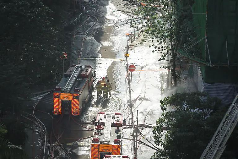 Firefighters-walk-at-the-site-of-a-fire-damaged-residential-block-at-Wang-Fuk-Court-housing-complex-following-a-deadly-fire-in-Tai-Po-Hong-Kong-China-November-29-2025-REUTERS-Tyrone-Siu-SEARCH-HONG-KONG-FIRE-PICTURE-FOR-THIS-STORY-SEARCH-WIDER-IMAGE-FOR-ALL-STORIES