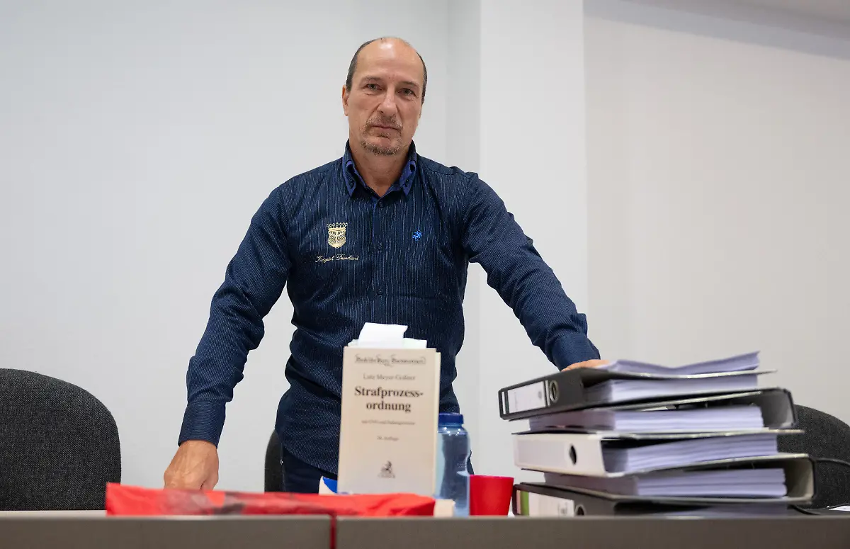 Reichsbuerger-Aktivist-Peter-Fitzek-bereitet-sich-in-einem-Saal-des-Landgerichts-Dessau-auf-den-Beginn-der-Verhandlung-vor-Fitzek-der-sich-selbst-auch-Koenig-von-Deutschland-nennt-war-vor-rund-einem-Jahr-wegen-vorsaetzlicher-Koerperverletzung-und-Beleidigung-schuldig-gesprochen-und-zu-acht-Monaten-Freiheitsstrafe-ohne-Bewaehrung-verurteilt-worden-Weil-Berufung-eingelegt-wurde-wird-der-Fall-nun-noch-einmal-verhandelt