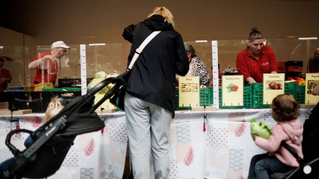 Eine-Frau-steht-mit-Kinderwagen-vor-der-Lebensmittelausgabe-in-der-Ausgabestelle-Paul-Schneider-Haus-der-Berliner-Tafel-Jeden-Montag-findet-die-Ausgabe-statt-Zum-bevorstehenden-Bundestafeltreffen-kommen-Vertreter-der-Tafeln-aus-ganz-Deutschland-zusammen-um-einen-neuen-geschaeftsfuehrenden-Vorstand-der-Tafel-Deutschland-zu-waehlen-und-diverse-Themen-zu-diskutieren