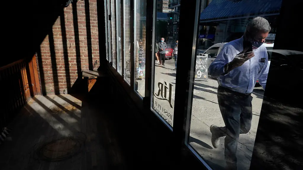 A-passer-by-walks-past-an-empty-restaurant-left-Tuesday-Oct-6-2020-in-Boston-The-number-of-Americans-seeking-unemployment-benefits-fell-slightly-last-week-to-a-still-high-840-000-evidence-that-job-cuts-remain-elevated-seven-months-into-the-pandemic-recession