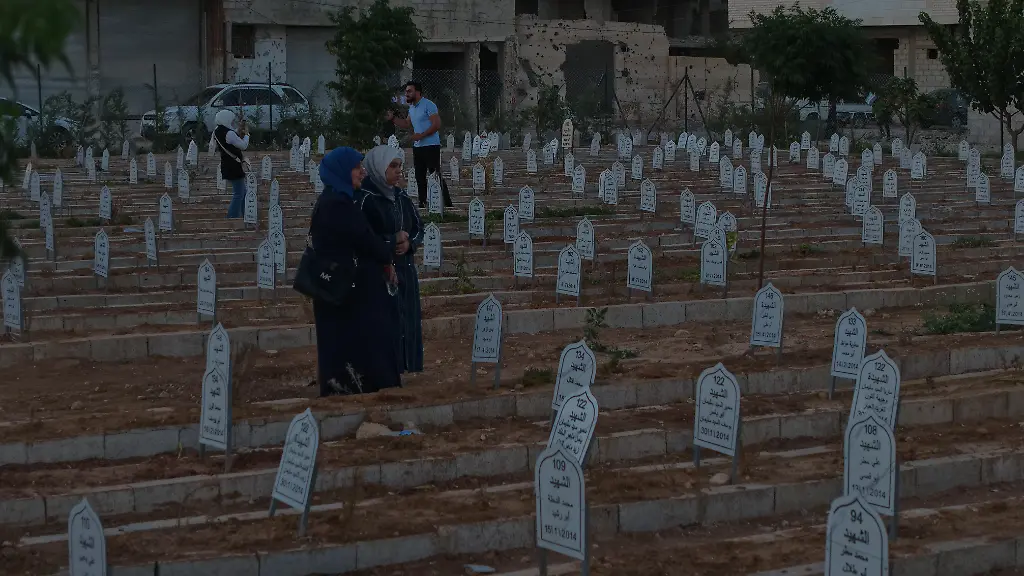 DARAYYA-SYRIA-AUGUST-26-People-visit-graves-as-they-gather-in-the-Syrian-city-of-Darayya-to-commemorate-the-victims-of-the-2012-massacre-carried-out-by-forces-of-the-ousted-Bashar-al-Assad-regime-on-August-26-2025-The-massacre-which-occurred-on-August-26-2012-resulted-in-the-killing-of-at-least-800-civilians-including-women-and-children-A-candlelit-memorial-ceremony-was-held-at-a-mass-grave-site-to-honor-the-memory-of-those-lost