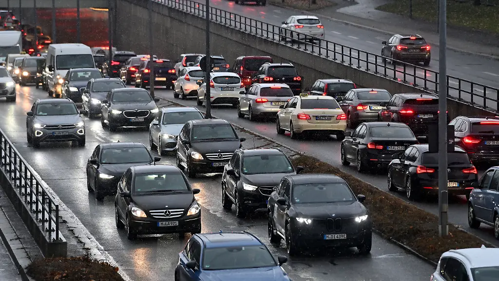 Abendlicher-dichter-Strassenverkehr-auf-dem-Mittleren-Ring-in-Muenchen-Stau-Stop-and-go-zaehfliesend-verstopfte-Hauptverkehrsstrasse-Mittlerer-Ring-dichter-Strassenverkehr
