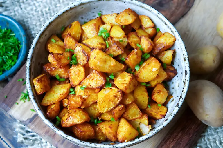 Nur-kleine-Mengen-Fett-bekommen-Bratkartoffeln-per-Oelsprueher-ab-werden-mit-Salz-und-Paprikapulver-gewuerzt-und-kommen-in-den-Airfryer-Nach-25-Minuten-sind-die-Kartoffelstuecke-richtig-schoen-knusprig