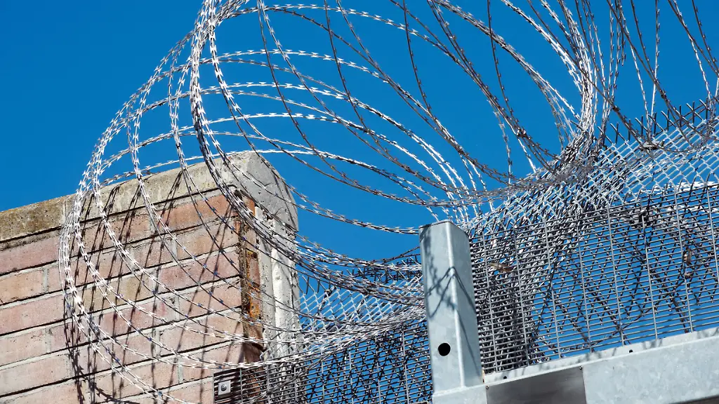 Stacheldraht-auf-der-Mauer-einer-Einrichtung-des-Massregelvollzugs-in-Brandenburg-wo-psychisch-kranke-verurteilte-Straftaeter-untergebracht-und-therapiert-werden-Der-Massregelvollzug-ist-eine-staatliche-Aufgabe-in-der-Zustaendigkeit-der-Laender-Gesetzliche-Grundlage-ist-das-Brandenburgische-Psychisch-Kranken-Gesetz-BbgPsychKG-in-der-novellierten-Fassung-vom-5-Mai-2009-Er-wird-im-Land-Brandenburg-in-den-forensischen-Kliniken-in-Eberswalde-Brandenburg-Havel-und-Teupitz-durchgefuehrt