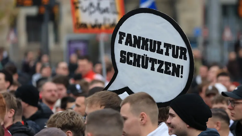 Fussballfans-aus-der-ganzen-Bundesrepublik-protestieren-gemeinsam-in-der-Leipziger-Innenstadt-gegen-strengere-Sicherheitsmassnahmen-bei-Fussballspielen-Grund-fuer-die-Demonstration-sind-Plaene-der-Innenminister-der-Laender-die-Vorkehrungen-in-den-Stadien-zu-verschaerfen-Dabei-ist-von-personalisierten-Tickets-mehr-KI-Ueberwachung-und-einer-Ausweitung-von-praeventiven-Stadionverboten-die-Rede