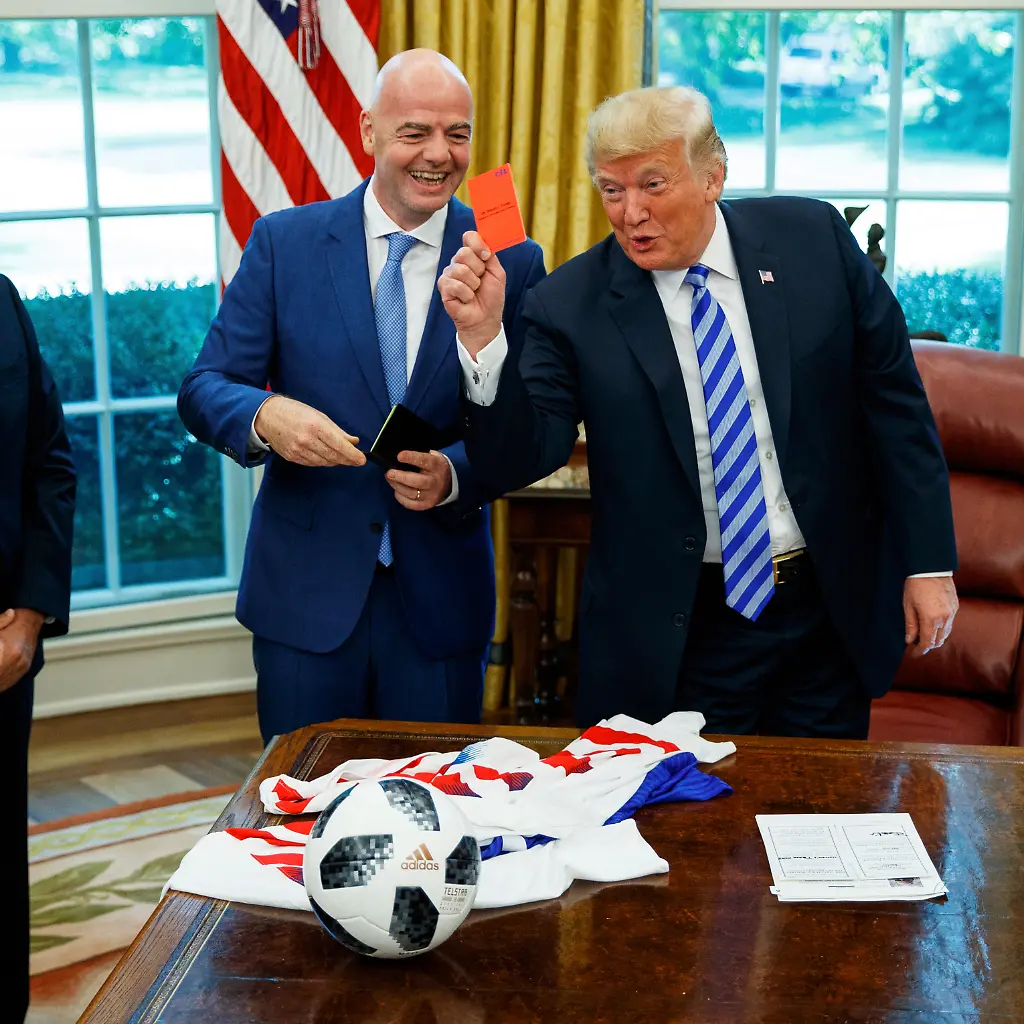 FILE-President-Donald-Trump-holds-up-a-red-card-during-a-meeting-with-FIFA-president-Gianni-Infantino-center-and-United-States-Soccer-Federation-president-Carlos-Cordeiro-left-in-the-Oval-Office-of-the-White-House-Aug-28-2018-in-Washington