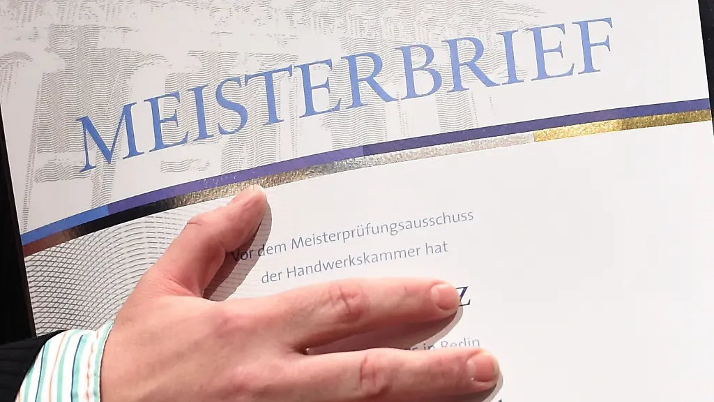 Ein-junger-Mann-freut-sich-bei-der-Meisterfeier-ueber-seinen-Meisterbrief-Vier-Handwerkerinnen-und-54-Handwerker-aus-Ostbrandenburg-haben-am-Samstag-in-Frankfurt-Oder-ihre-Meisterbriefe-erhalten