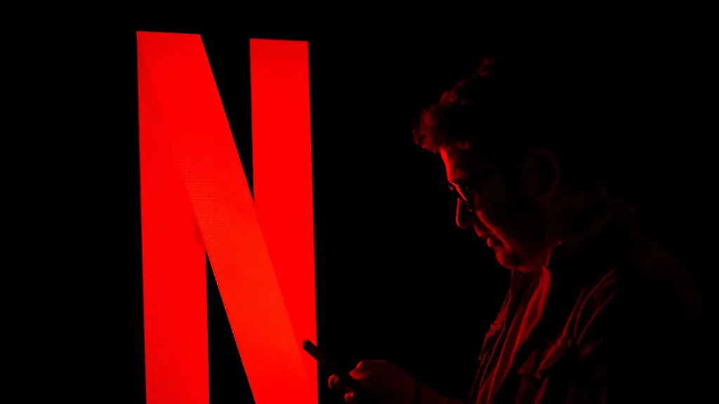 ANKARA-TURKIYE-NOVEMBER-1-Logo-of-Netflix-is-displayed-on-a-digital-screen-with-a-man-looking-at-his-mobile-phone-in-Ankara-Turkiye-on-November-1-2025
