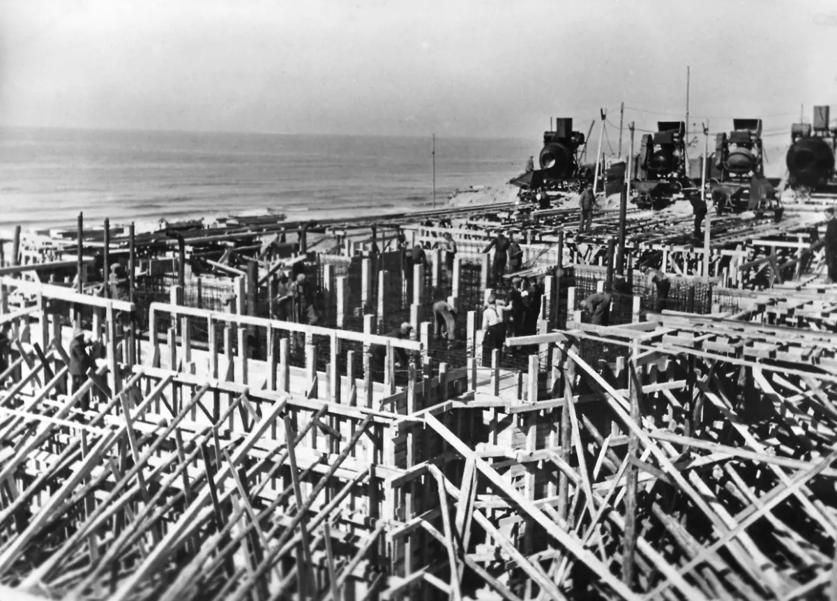 Ein-deutscher-Bunker-entsteht-am-Atlantikwall-Im-Hintergrund-sind-Betonmischer-zu-erkennen-bereit-um-die-Holzumschachtelung-und-die-Stahlgeflechte-auszufuellen-Die-Arbeitskraefte-bestehen-z-T-aus-Zivilisten