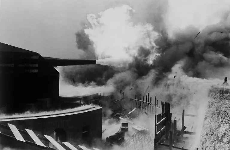 2-G56-A4-1942-1-2-Weltkrieg-Atlantikwall-Geschuetz-Geschichte-2-Weltkrieg-Atlantikwall-dt-Kuestenbefestigung-1942-44-an-der-niederlaend-belg-und-franz-Kueste-Schweres-Geschuetz-am-Atlantikwall-gibt-Feuer-Foto-undat-E-Heavy-cannon-Atlantic-Line-WWII-History-World-War-II-Atlantic-Line-German-coastal-fortification-built-1942-44-on-the-Dutch-Belgian-and-French-coasts-A-heavy-cannon-on-the-Atlantic-Line-is-fired-Photo-undated-F-2eme-GM-Mur-de-l-Atlantique-Canon-lourd-Histoire-Seconde-Guerre-mondiale-Mur-de-l-Atlantique-Construit-en-1942-44-sur-la-cote-neerlandaise-belge-et-francaise-Canon-lourd-sur-me-Mur-de-l-Atlan-tique-en-action-Photo
