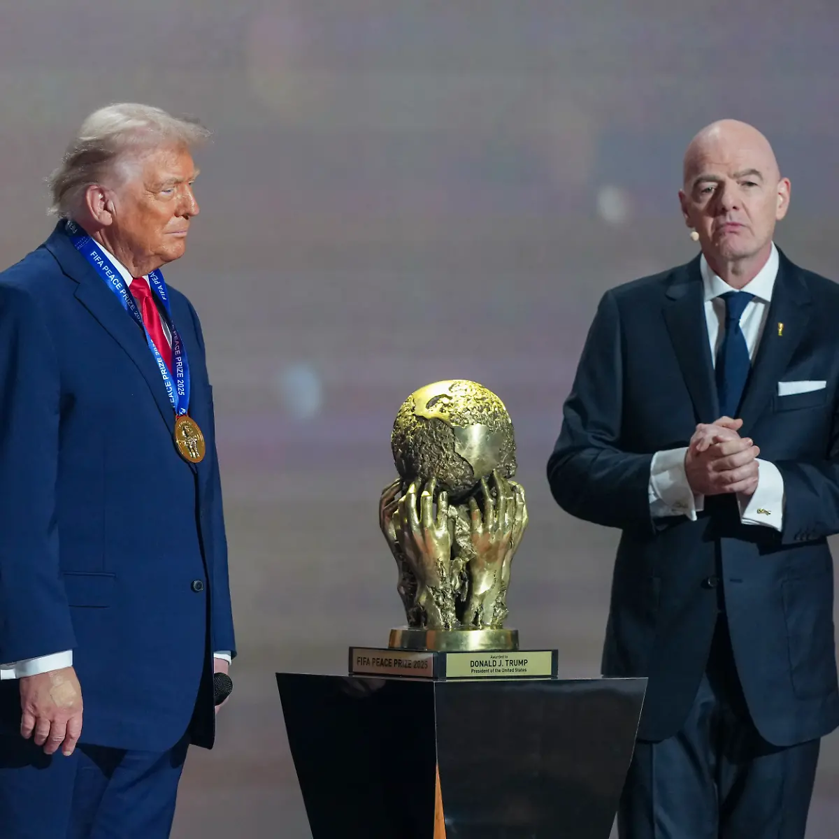 L-R-US-President-Donald-Trump-looks-on-as-he-receives-the-FIFA-Peace-Prize-from-FIFA-President-Gianni-Infantino-during-the-draw-for-the-2026-FIFA-Football-World-Cup-taking-place-in-the-US-Canada-and-Mexico-at-the-Kennedy-Center-in-Washington-DC-on-December-5-2025