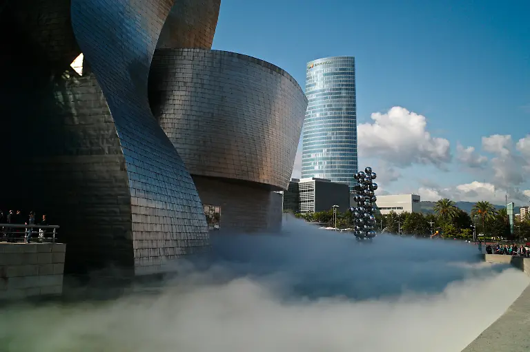 The-Sculpture-Tall-Tree-The-Eye-by-Anish-Kapoor-and-the-Iberdrola-building-surrounded-by-The-Fog-sculpture-designed-as-a-sculptural-medium-by-Fujiko-Nakaya-The-Guggenheim-Museum-in-Bilbao-Kike-Calvo-via-AP-Images