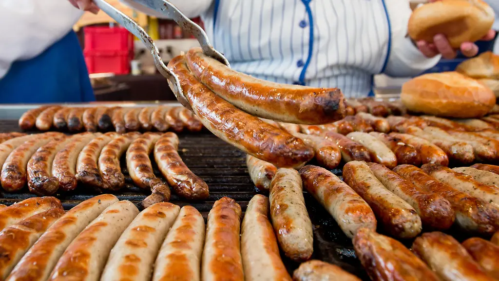 A-vendour-offers-bratwurst-at-Nuremberg-Christkindlesmarkt-in-Nuremberg-Germany-29-November-2013-With-a-prologue-the-Christ-Child-opened-the-famous-Christmas-market-this-afternoon