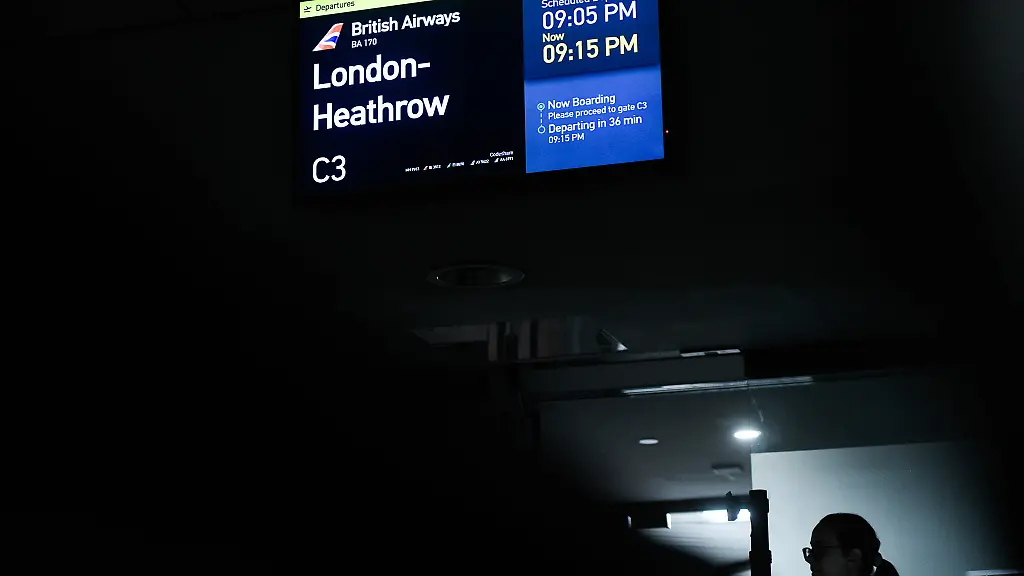 A-gate-agent-stands-next-to-a-gate-after-departing-passengers-boarded-the-last-international-flight-British-Airways-Flight-170-bound-for-London-Heathrow-leaving-the-old-Pittsburgh-International-Airport-terminal-Monday-Nov-17-2025-in-Pittsburgh