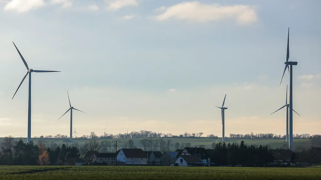 Mehrere-Windkraftanlagen-stehen-hinter-dem-kleinen-Ort-In-Thueringen-gelten-fuer-Windraeder-seit-2024-Mindestabstaende-zu-Wohngebieten-von-1000-Metern