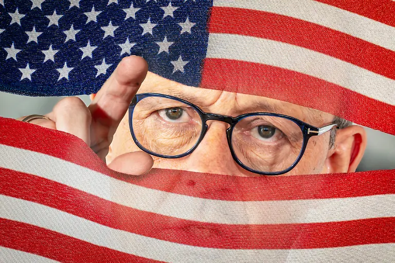 USA-Juni-2025-Bundeskanzler-Friedrich-Merz-vor-seinem-Treffen-mit-US-Praesident-Donald-Trump-Symbolfoto-Merz-schaut-gespannt-zwischen-den-Streifen-der-US-Flagge-hindurch-Antrittsbesuch-im-Weissen-Haus-am-Donnerstag-deutsch-amerikanische-Beziehungen-haben-sich-unter-Trump-verschlechtert-Politik-Politiker-Fotomontage