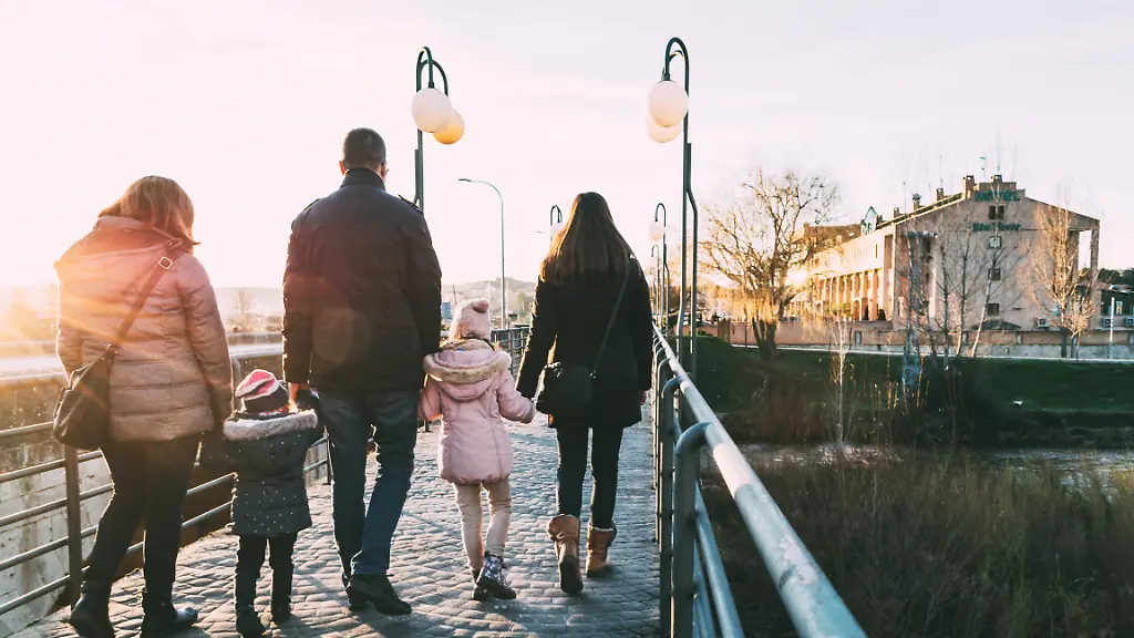 Father-walking-down-the-street-with-his-two-families-on-a-sunny-winter-s-afternoon