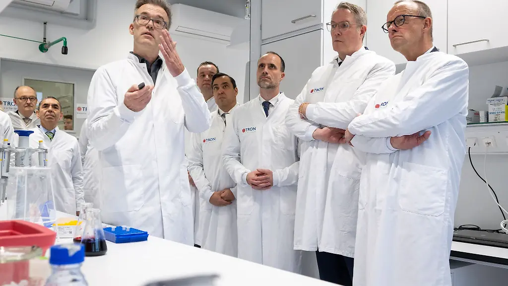 Kanzler-Merz-Ministerpraesident-Schweitzer-und-der-rheinland-pfaelzische-Wissenschaftsminister-Hoch-bekommen-ein-Projekt-erklaert-bei-dem-Hefe-fuer-die-Produktion-von-RNA-genutzt-werden-soll