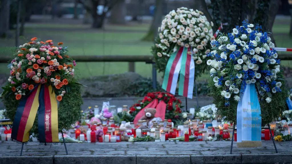 Kraenze-Blumen-und-Kerzen-am-Tatort-im-Park-Schoental-in-Aschaffenburg-am-Sonntag-26-01-2025-zum-Gedenken-der-Opfer-des-toedlichen-Messerangriffs-Am-Mittwoch-22-01-2025-waren-bei-einer-Messerattacke-in-Aschaffenburg-ein-zwei-Jahre-altes-Kita-Kind-und-ein-41-jaehriger-Mann-getoetet-worden-Drei-andere-Menschen-wurden-verletzt-Tatverdaechtig-ist-ein-offenbar-psychisch-kranker-28-jaehriger-Afghane-der-ausreisepflichtig-war-Siehe-epd-Meldung-vom-26-01