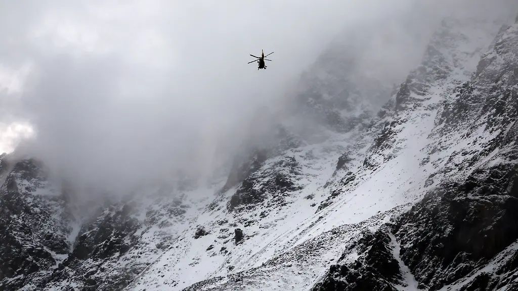 Ein-Hubschrauber-der-Bergrettung-fliegt-auf-der-Suche-nach-zwei-vermissten-Bergsteigern-vor-dem-mit-Schnee-bedeckten-Ortler-Gebirge-Nach-dem-Tod-von-mindestens-drei-deutschen-Bergsteigern-bei-einem-Lawinenunglueck-in-Suedtirol-ist-die-Suche-nach-zwei-Vermissten-wieder-aufgenommen-worden