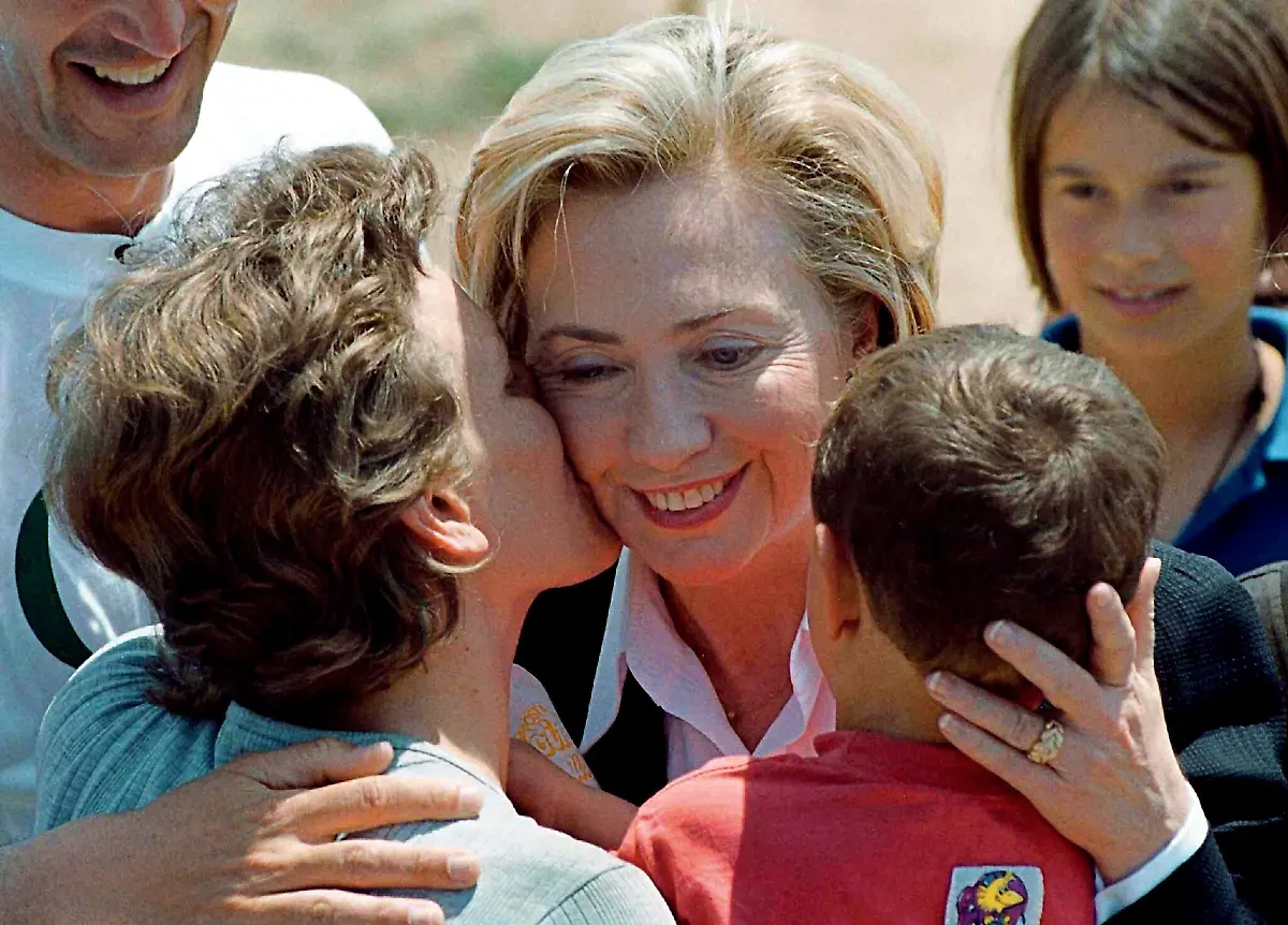 fs12-fs16-Die-amerikanische-First-Lady-Hillary-Clinton-r-wird-am-14-5-1999-im-mazedonischen-Fluechtlingslager-Stenkovac-von-zwei-albanischen-Fluechtlingskindern-aus-dem-Kosovo-gekuesst-Beim-Rundgang-durch-das-Camp-Stenkovec-bei-Skopje-klammerten-sich-kleine-Kinder-an-ihre-Haende-umarmten-und-kuessten-sie-Frauen-Hillary-Clinton-hoffte-dass-die-Unterstuetzung-fuer-dort-arbeitende-Organisationen-anhaelt-Das-Fluechtlingshilfswerk-UNHCR-hatte-gewarnt-dass-ihm-das-Geld-fuer-seine-Arbeit-zur-Versorgung-der-Vertriebenen-ausgehe-wenn-die-UNO-Mitgliedslaender-keine-neuen-Beitraege-zuschoessen