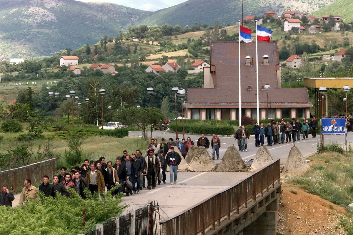 Rund-200-Kosovo-Fluechtlinge-ueberqueren-am-22-5-1999-die-albanische-Grenze-bei-Morina-Sie-gehoeren-zu-einer-Gruppe-von-rund-500-Maenner-aus-Kosovska-Mitrovica-die-Mitte-April-aus-einem-Fluechtlingskonvoi-abgefuehrt-und-in-ein-Gefaengnis-in-Smrekovica-gebracht-worden-Man-sah-allen-an-dass-sie-Schlimmes-durchgemacht-hatten-sagte-ein-UNHCR-Sprecher-Die-Maenner-haetten-Knochenbruecke-und-Bluterguesse-gehabt-und-seien-voellig-ausgezehrt-gewesen-Insgesamt-sind-bereits-eine-Dreiviertelmillion-Menschen-seit-Mitte-Maerz-aus-dem-Kosovo-gefluechtet-oder-vertrieben-worden