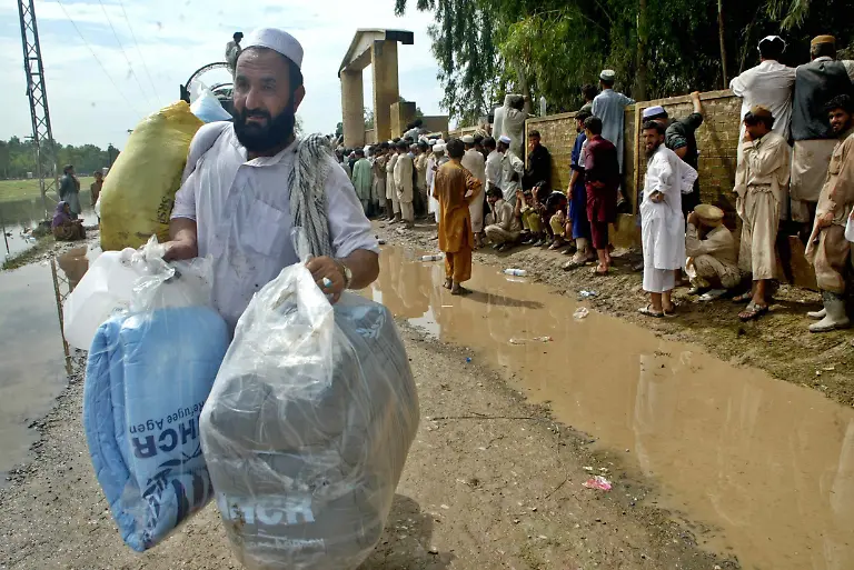 epa02279884-Flood-victims-receive-relief-goods-including-tents-mats-and-buckets-distributed-by-the-United-Nation-High-Commissioner-for-Refugees-UNHCR-in-Nowshera-a-town-of-Khyber-Pakhtunkhwa-province-Pakistan-on-09-August-2010-More-than-1500-people-across-Pakistan-have-been-killed-and-hundreds-of-thousands-stranded-due-to-flash-floods-triggered-by-the-ongoing-spell-of-monsoon-rains-The-worst-floods-the-country-has-faced-in-several-decades-washed-away-millions-of-hectares-of-crops-submerged-villages-and-destroyed-roads-and-bridges-in-the-north-western-province-of-KhyberPakhtunkhwa-parts-of-the-Pakistan-administered-Kashmir-region-and-the-eastern-province-of-Punjab