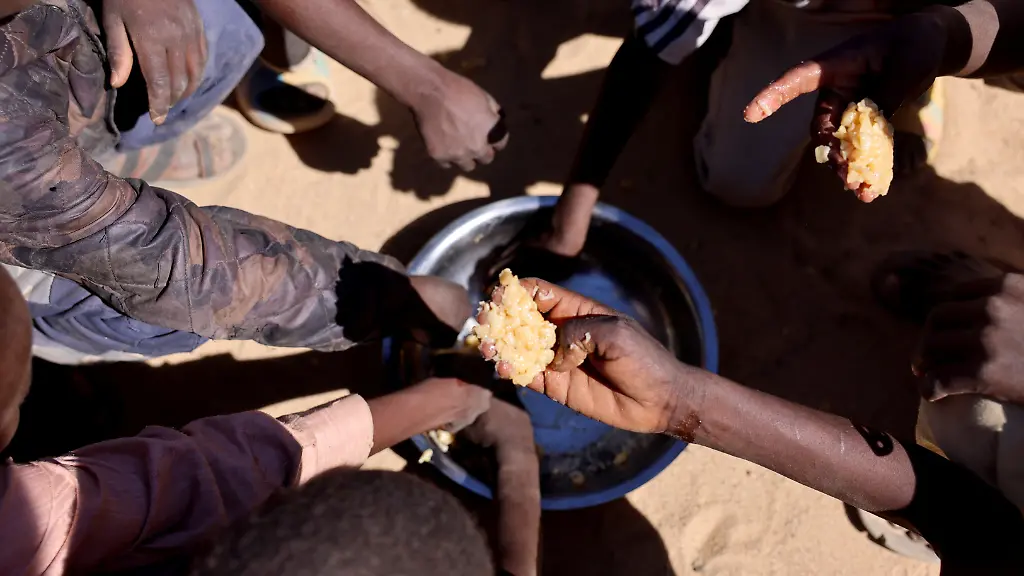Sudanese-orphaned-refugees-children-from-al-Fashir-share-a-free-meal-of-pasta-and-meat-provided-by-the-Group-Kitchen-Project-led-by-Najwa-Isa-Adam-inside-the-Tine-transit-camp-in-eastern-Chad-as-they-flee-ongoing-clashes-between-the-paramilitary-Rapid-Support-Forces-RSF-and-the-Sudanese-army-November-22-2025