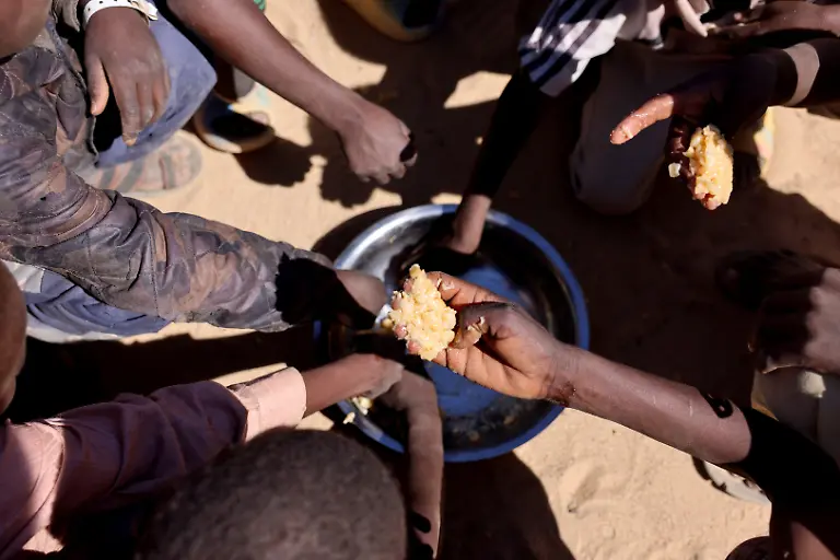 Sudanese-orphaned-refugees-children-from-al-Fashir-share-a-free-meal-of-pasta-and-meat-provided-by-the-Group-Kitchen-Project-led-by-Najwa-Isa-Adam-inside-the-Tine-transit-camp-in-eastern-Chad-as-they-flee-ongoing-clashes-between-the-paramilitary-Rapid-Support-Forces-RSF-and-the-Sudanese-army-November-22-2025