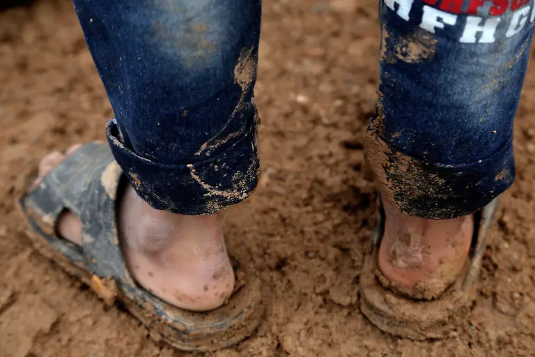 ARBIL-IRAQ-JANUARY-04-An-Iraqi-kid-fled-from-Islamic-State-of-Iraq-and-Levant-ISIL-members-attacks-with-his-family-has-difficulty-in-walking-with-a-pair-of-slipper-at-the-muddy-area-of-Harshem-refugee-camp-in-Ankawa-neighborhood-of-Arbil-Iraq-on-January-04-2015