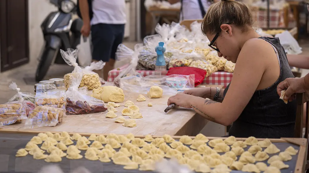BARI-ITALY-JUNE-15-A-woman-prepares-home-made-pasta-locally-called-orecchiette-are-seen-at-Strada-delle-Orecchiette-the-most-famous-street-in-Bari-Italy-on-June-15-2024-The-port-city-of-Bari-located-on-the-Adriatic-Sea-in-southeastern-Italy-attracts-the-attention-of-tourists-with-its-historical-and-cultural-richness-as-well-as-its-street-famous-for-pasta