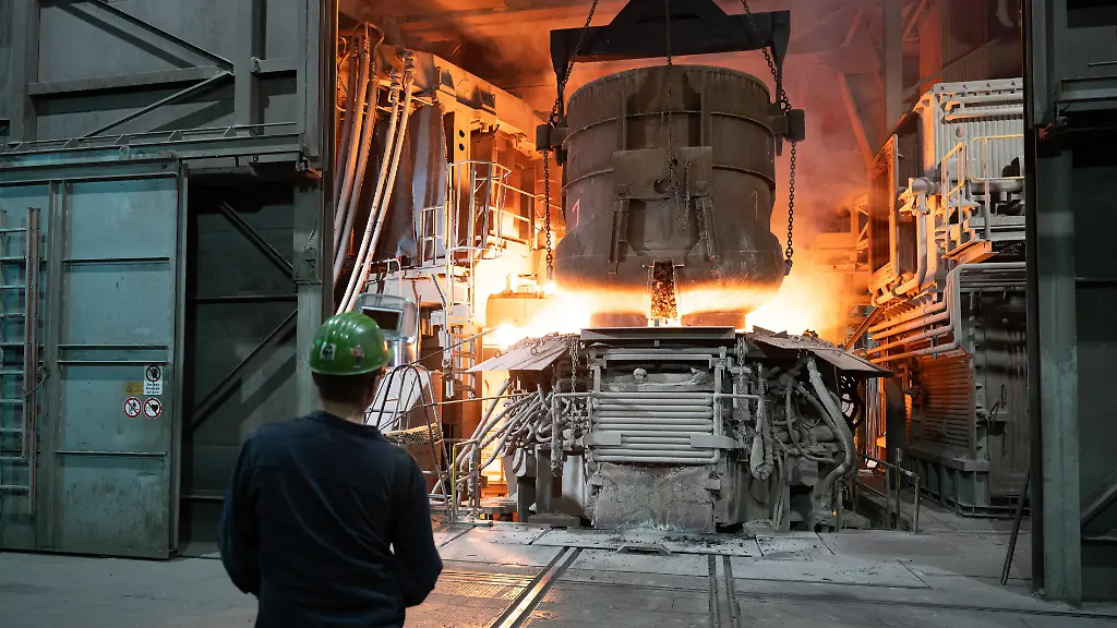 Ein-Mitarbeiter-steht-in-einer-Werkhalle-der-BGH-Edelstahl-Freital-GmbH-hinter-einem-Schrottkorb-an-einem-Lichtbogenofen-Anlass-ist-der-4-Saechsische-Stahlgipfel