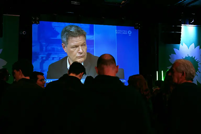 Gruenen-Anhaenger-verfolgen-auf-der-Wahlparty-von-Buendnis-90-Die-Gruenen-auf-einer-Leinwand-die-Fernsehsendung-Berliner-Runde-von-ARD-und-ZDF-in-der-gerade-Robert-Habeck-Buendnis-90-Die-Gruenen-Bundesminister-fuer-Wirtschaft-und-Klimaschutz-und-Kanzlerkandidat-spricht-Am-Sonntag-findet-die-vorgezogene-Wahl-zum-21-Deutschen-Bundestag-statt