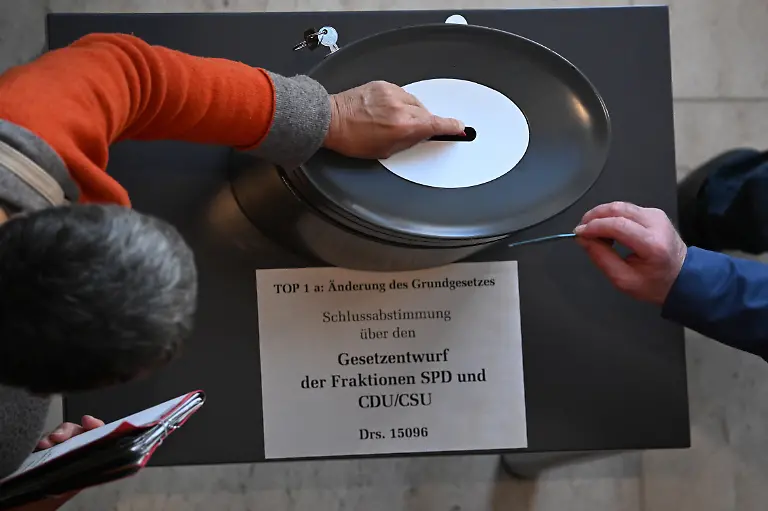 Abgeordnete-stimmen-namentlich-ab-ueber-die-Grundgesetzaenderung-nach-einem-Entwurf-von-SPD-und-CDU-CSU-in-der-214-Plenarsitzung-der-20-Legislaturperiode-im-Deutschen-Bundestag-Hauptthema-dieser-zweiten-Sondersitzung-des-alten-Bundestages-nach-der-vorgezogenen-Bundestagswahl-ist-die-Reform-der-Schuldenbremse-als-Voraussetzung-fuer-das-geplante-milliardenschwere-Finanzpaket-der-zukuenftigen-Bundesregierung-fuer-Verteidigung-Infrastruktur-und-Klimaschutzmassnahmen