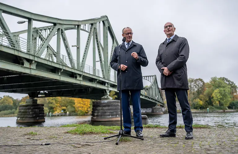 Bundeskanzler-Friedrich-Merz-l-CDU-steht-neben-Dietmar-Woidke-SPD-Ministerpraesident-von-Brandenburg-neben-der-Glienicker-Bruecke-beim-Pressestatement-nach-seinem-Antrittsbesuch-in-Brandenburg